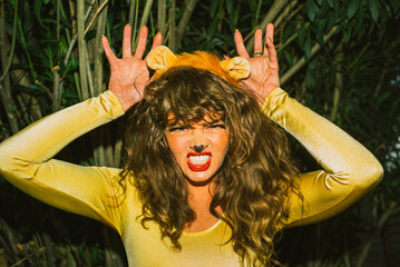 Woman dressed as lion lioness costume  - obrazy, fototapety, plakaty