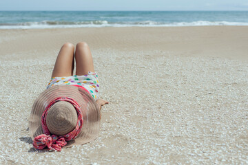 a woman lying in front of the sea on beach sand and shells. concept of peace and tranquility on the mediterranean coast.