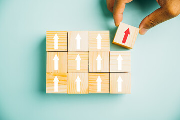 Male hands carefully arranging wooden blocks as steps, symbolizing the path to business growth. The...