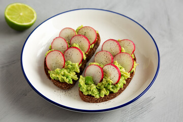 Homemade Radish Avocado Toast with Salt and Pepper on a Plate, side view.