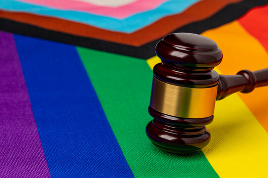 Rainbow pride flag and gavel. LGBTQ+ discrimination, legislation, and gay rights concept.
