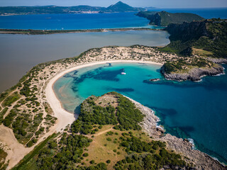 Aerial view of Voidokilia beach on Peloponnese in Messinia / Greece with clear blue water and catamaran sailing boat in the bay