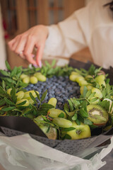 a fruit bouquet of blueberries and grapes stands on a table in the kitchen