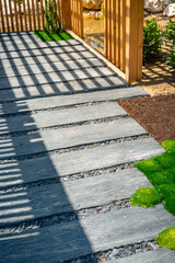 Detail of slate path with bark mulch and native plants in Japanese garden. Landscaping and...