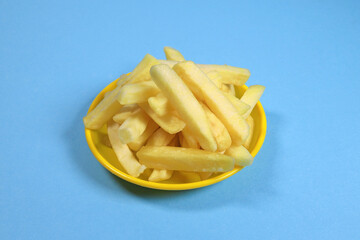 french fries, fried potatoes on a plate isolated on blue background