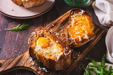 Appetizing brioche baked with egg and cheese on the board