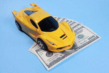 Toy car on dollars, cost concept, auto insurance