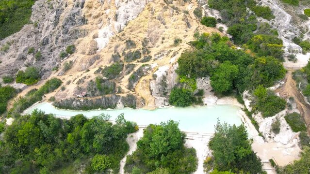 Bagno Vignoni natural pools along the city hill in Tuscany, view in spring season from drone