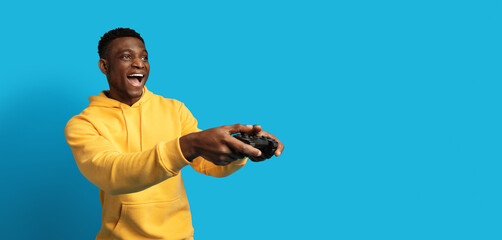 Thrilled african american man playing video games with joystick, panorama © Prostock-studio
