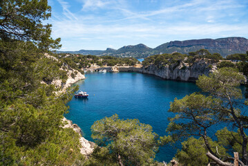 Fototapeta na wymiar Spectacular view of Calanque de Port-Miou with mooring ship and Canaille cape at background. Calanques National Park, Cassis, France. Travel, nature, environment, beautiful landscape concepts.