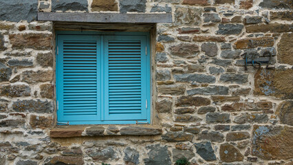 Fototapeta na wymiar Traditional Mediterranean, Aegean type stone house window with blue blinds