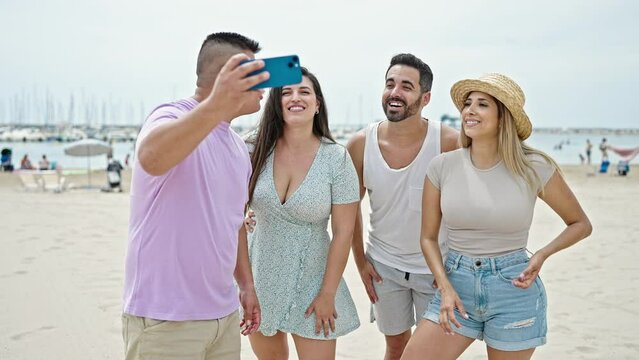 Group of people make selfie by smartphone smiling at beach