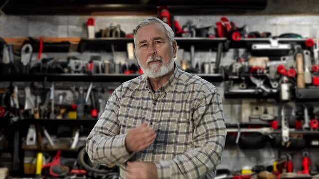 Senior man lifts a heavy moving box and injures his back, experiencing a great deal of pain