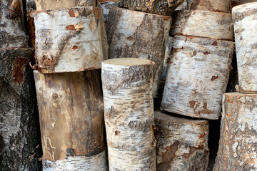 Background of stacked chopped wood logs. Pile of wood logs ready for winter. Wooden stumps, firewood stacked in heap