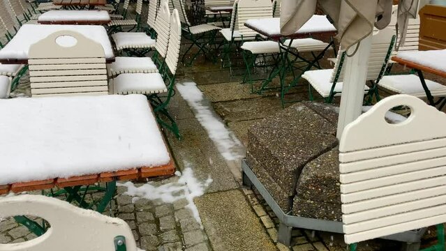 Snow falling on restaurant tables and chairs outdoor
