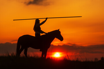 silhouette of a rider on a horse with the setting sun