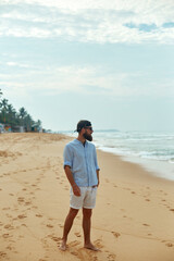 Portrait of handsome bearded man in shirt on the beach
