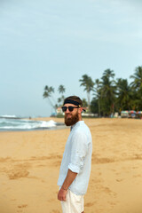 Portrait of handsome bearded man in shirt on the beach