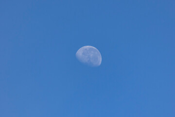 The waning moon in a blue sky. Nature. Astronomy