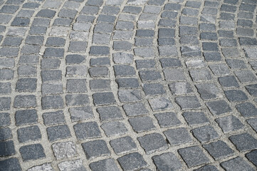 Cobblestone pattern on the road. Cobblestone texture on the street, close up. Brick floor tiles.