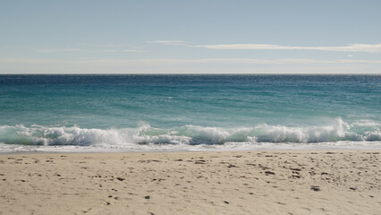 Fototapeta na wymiar blue waves on a sandy empty beach in Cannes in spring