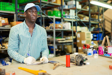 Store warehouse worker makes notes in a notebook, keeps track of goods