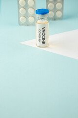 Close up shot of vaccine medical ampoule packed pills for Covid- treatment on pastel blue background