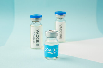 Close up shot of vaccines for treatment Covid- in medical ampoules on white blue background