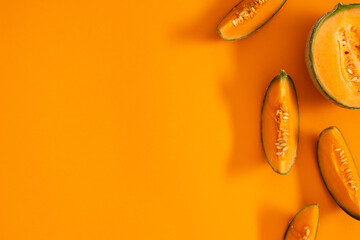 Melon slice on orange background. Creative layout made of fresh melon. Flat lay, top view, copy...
