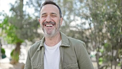 Middle age man smiling confident standing at park - Powered by Adobe