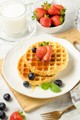 Waffles com frutas e mel em fundo branco