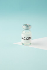 Close up view of vaccine ampoule on pastel blue and white background with free space