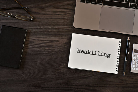 There is notebook with the word Reskilling. It is as an eye-catching image.