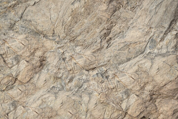 Obraz na płótnie Canvas Rock texture. Light brown gray beige stone granite background. Rough cracked mountain surface. Close-up. Solid. Natural.