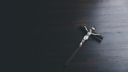 Wooden Christian cross crucifix on a grunge board background. Wooden Christian cross on grey table...