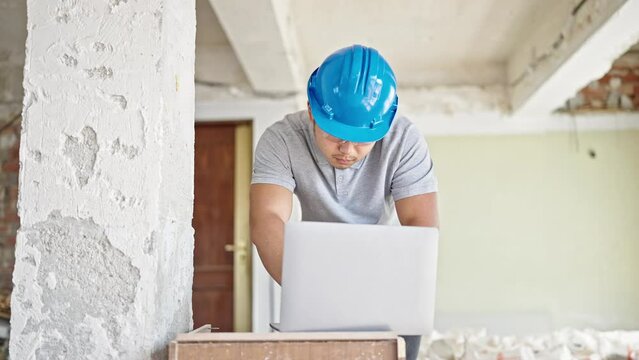  architect using laptop stressed at construction site