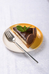 slice of Dutch pie on a white and yellow plate on a table and yellow with a white tablecloth photographed close up 