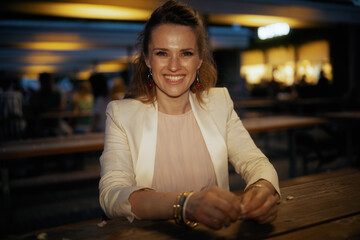 Portrait of smiling elegant woman in dress and jacket in city