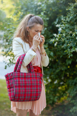 trendy female in dress and jacket in city has allergy attack
