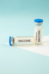 Horizontal view of COVID- VACCINE in closed ampoules on pastel blue and white background with free space
