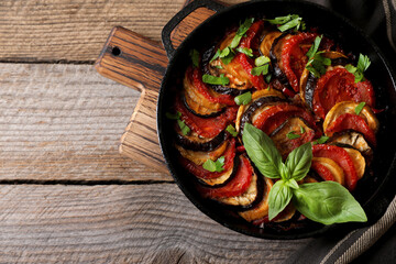 Delicious ratatouille on wooden table, top view. Space for text