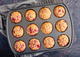 Freshly Baked Raspberry Muffins in a Nonstick Muffin Pan: Breakfast or dessert muffins made with fruit viewed from directly above in muffin tin