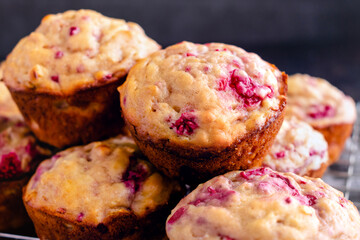 Freshly Baked Raspberry Muffins Piled on a Wire Cooling Rack Close Up: Breakfast or dessert muffins made with fruit viewed closeup