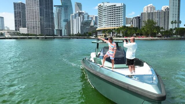 Aerial orbit shot of a wealthy man in his yacht being recorded by a videographer near the coast of Miami in the United States.