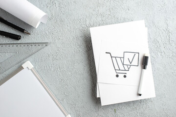 Top view of basket tick on white sheet pens ruler desk blank on gray sand background