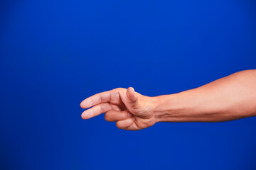 Human hand on a blue background.