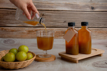 Fresh green amla or indian gooseberry fruits with gooseberry juice, healthy diet on wood table. 
