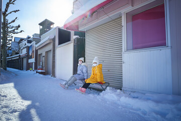 Two sisters sitting and resting in the streets of Otaru, Hokkaido