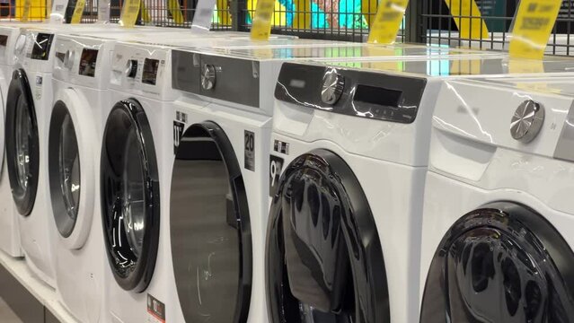 Rows of new washing machines stand in a major appliance store