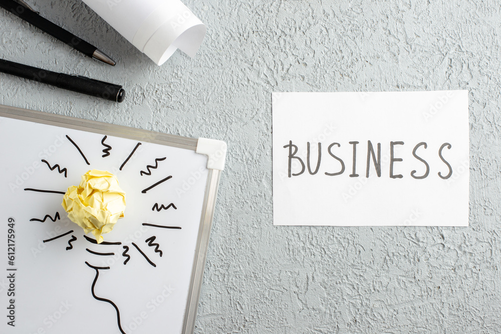 Wall mural top view of sheet with business writing incompletely drawn thing and crushed wrapped paper on white 